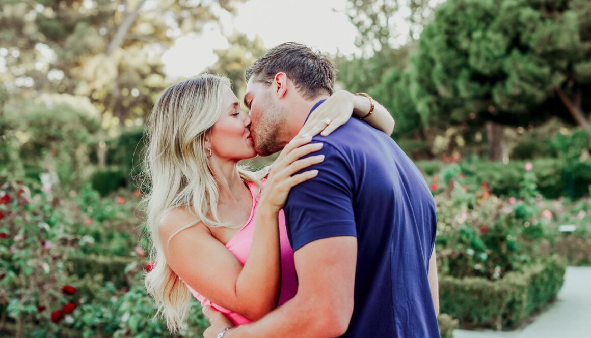 Pareja besándose al aire libre en sesión fotográfica de verano 2025, estilo natural y romántico.