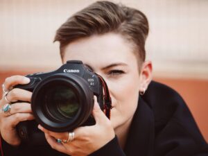 Canon EOS R1 vs Nikon Z9: ¿Cuál es la mejor cámara en 2025? - nicoletalupuagency Primer plano de una fotógrafa sosteniendo la Canon EOS R1