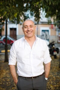 Retrato profesional de hombre maduro sonriendo al aire libre, ideal para perfiles de citas como Tinder o Bumble.