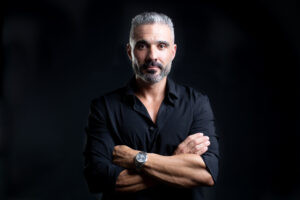 Professional executive portrait of confident businessman with dark background and editorial lighting.