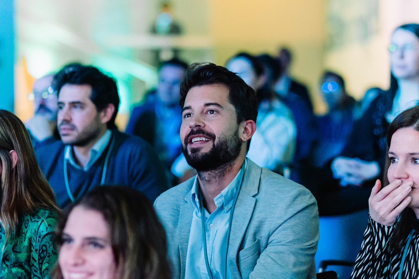 Attendees smiling and reacting during a conference session in Madrid