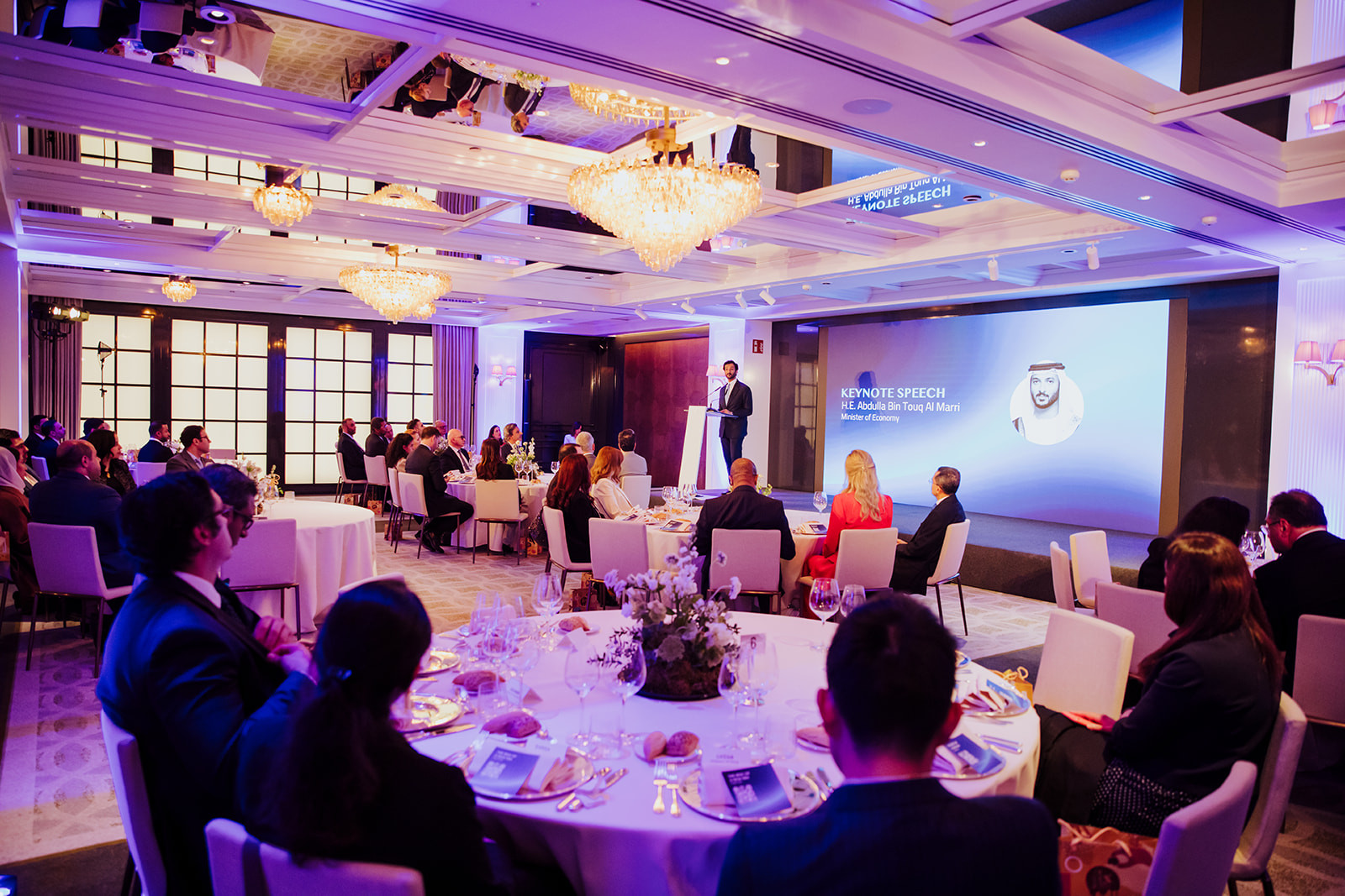 Corporate gala dinner in a Madrid hotel ballroom with round tables and a stage