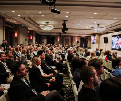 Event photography budget: full audience following a conference session in a hotel ballroom