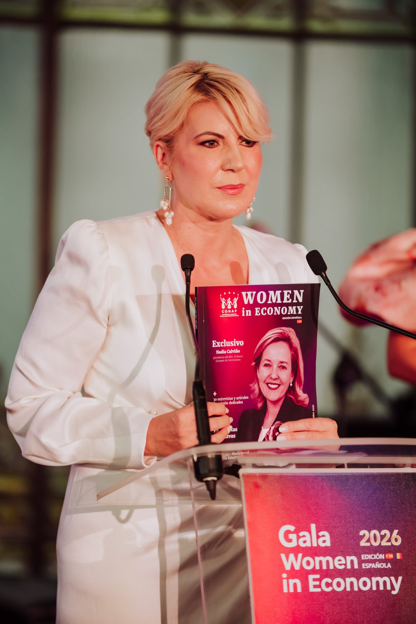 Event Photographer in Madrid: Our Coverage of the CONAF Women in Economy Gala at the Real Casino de Madrid - nicoletalupuagency Cristina Chiriac, founding president of CONAF, at the branded lectern of the Gala Women in Economy 2026 in Madrid