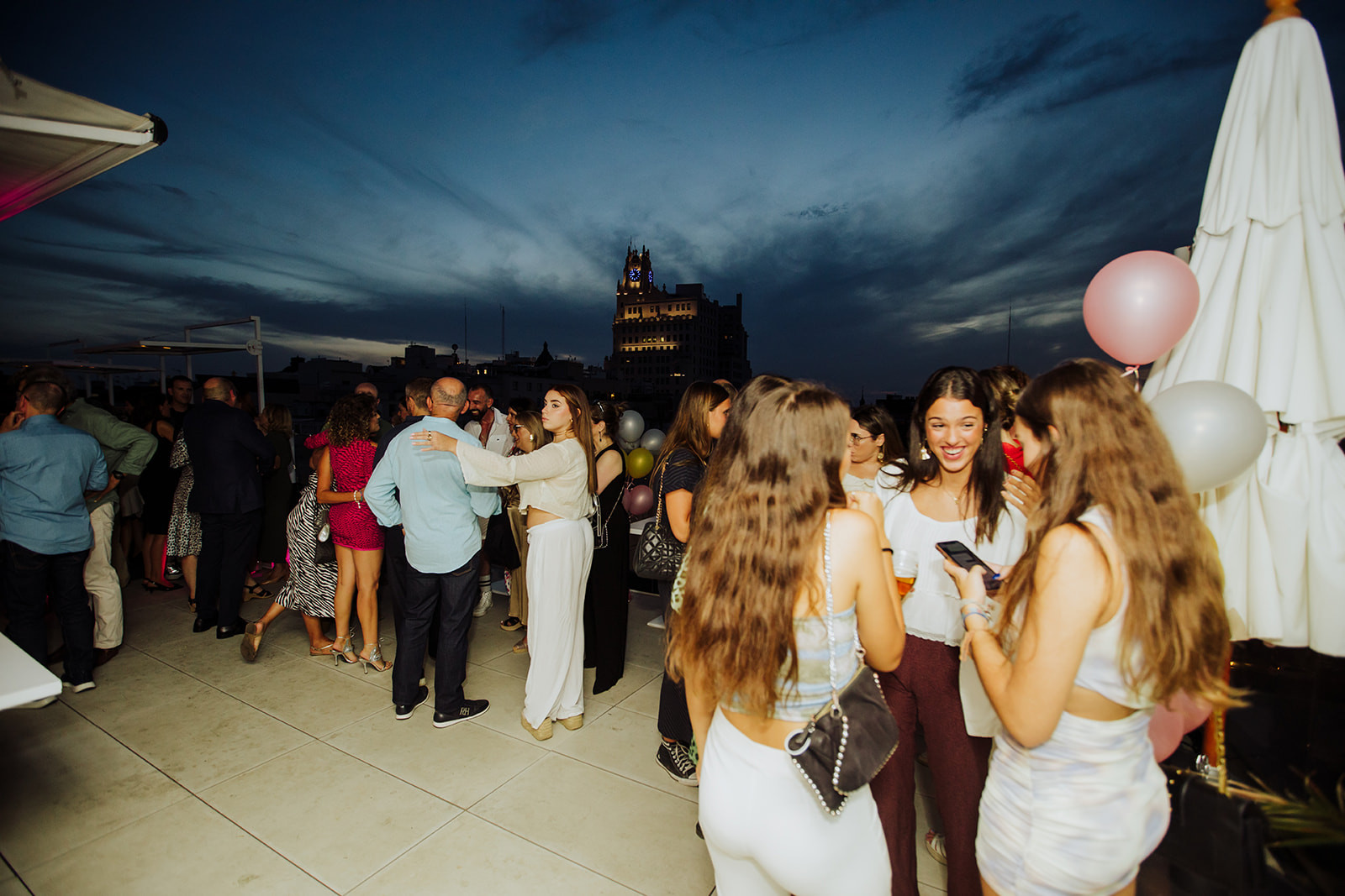 Guests networking at an evening rooftop event in Madrid