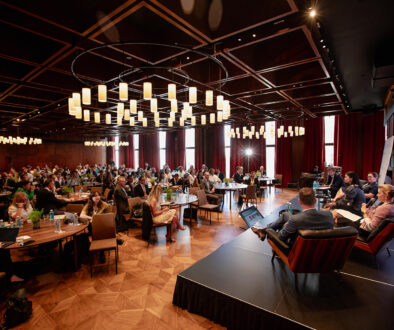 Sustainable event photography: conference hall in Madrid with guests at tables and a stage